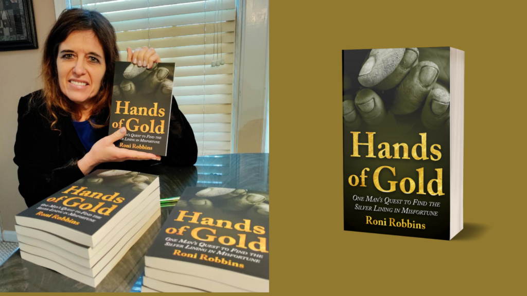 Roni Robbins holding her novel Hands of Gold